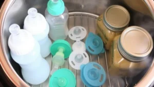 Baby bottles and kitchen tools being steriized in a presure cooker