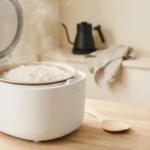Large rice cooker filled with fluffy white rice on a bright family kitchen countertop